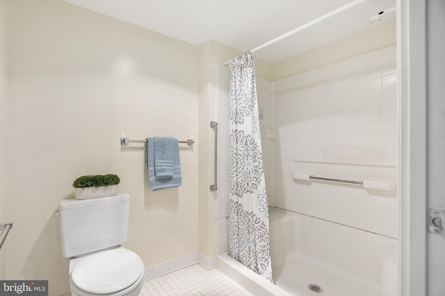 full bath featuring toilet, a shower stall, baseboards, and tile patterned flooring