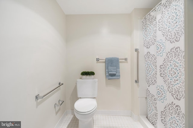 full bath featuring toilet, tile patterned flooring, baseboards, and a shower stall