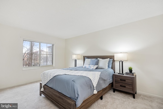 bedroom with baseboards and light colored carpet