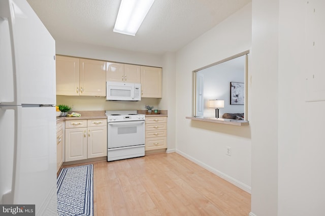 kitchen with white appliances, light wood finished floors, baseboards, light countertops, and a textured ceiling