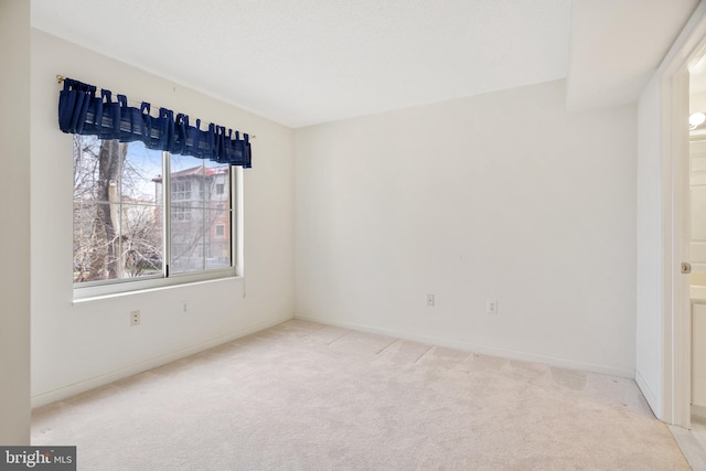 empty room with light carpet and baseboards