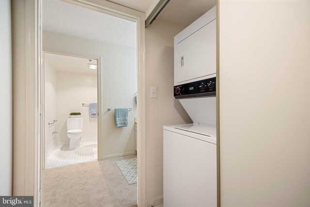 clothes washing area featuring light carpet, laundry area, and stacked washer / dryer