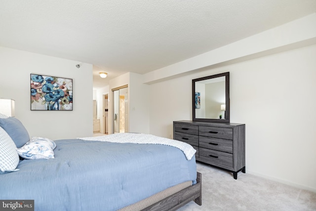 bedroom with a textured ceiling and light colored carpet