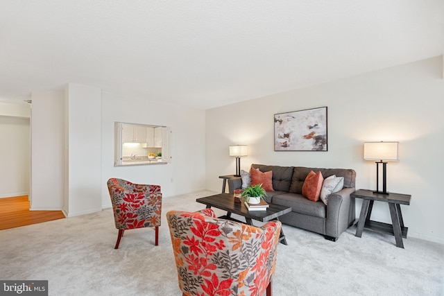 living room featuring light carpet and baseboards