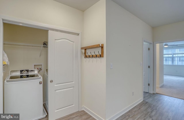 laundry area featuring light colored carpet, washer / dryer, and ceiling fan