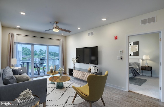 living room with ceiling fan and light hardwood / wood-style floors