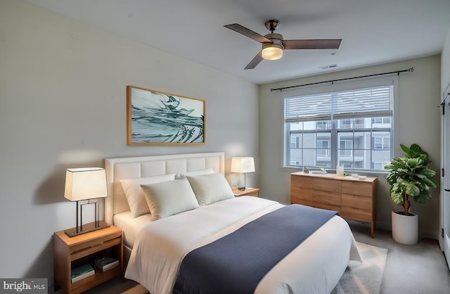 bedroom with ceiling fan and light carpet