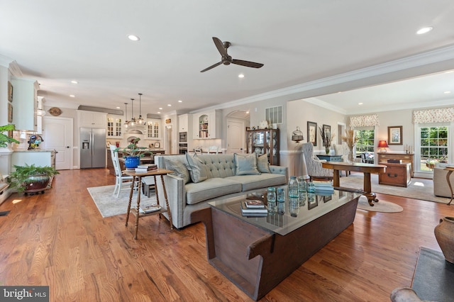 living room with crown molding, hardwood / wood-style floors, and ceiling fan