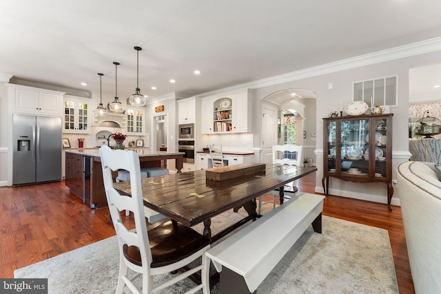 dining space with ornamental molding and dark wood-type flooring