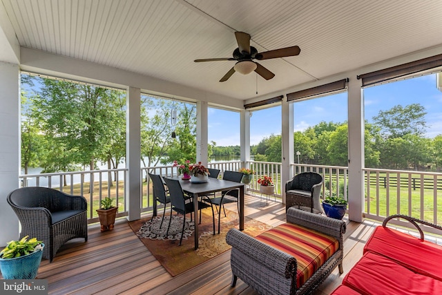 sunroom / solarium featuring a wealth of natural light, ceiling fan, and a water view