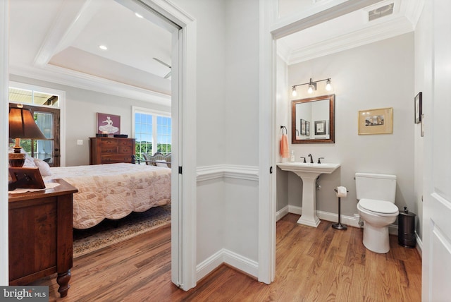 bedroom featuring ornamental molding, a tray ceiling, and light hardwood / wood-style floors