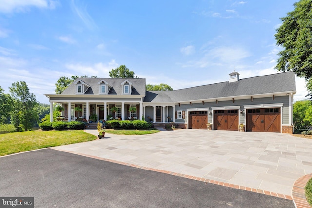 cape cod home with a porch, a garage, and a front lawn