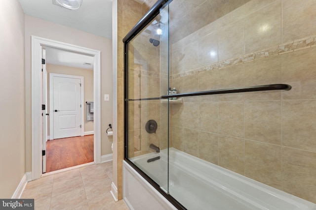 bathroom with tile patterned floors and bath / shower combo with glass door