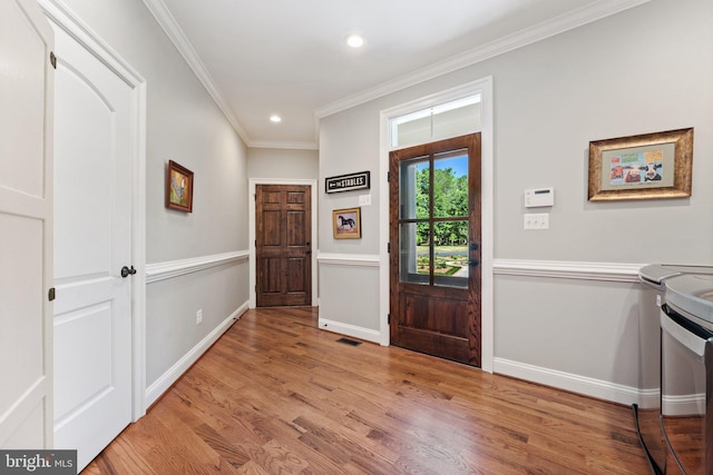 foyer entrance featuring ornamental molding and light wood-type flooring