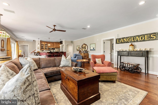 living room with crown molding, ceiling fan, and light hardwood / wood-style floors