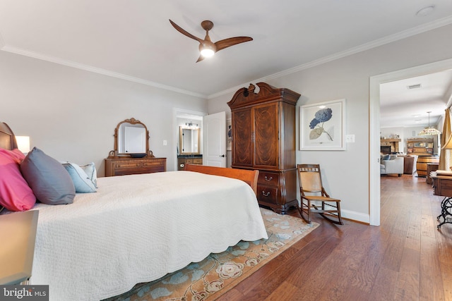 bedroom with dark wood-type flooring, ornamental molding, ceiling fan, and ensuite bathroom