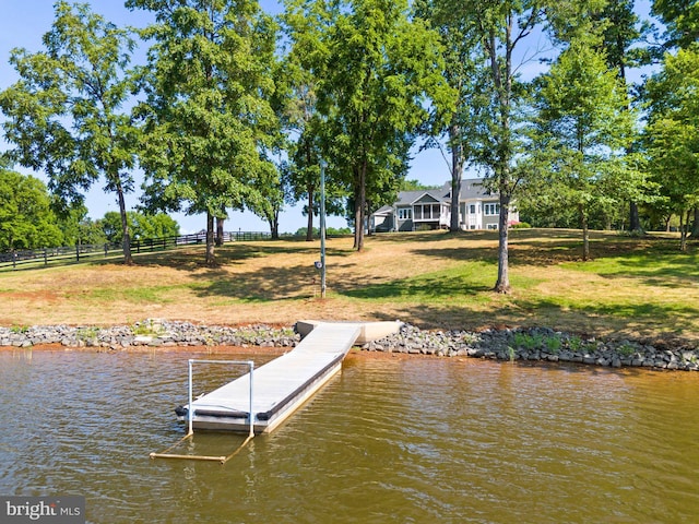 dock area with a water view and a lawn