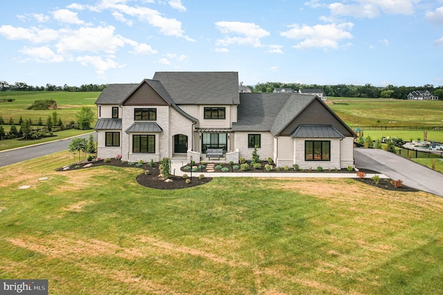 view of front facade with a rural view and a front lawn