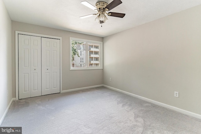 unfurnished bedroom with ceiling fan, a closet, and light colored carpet