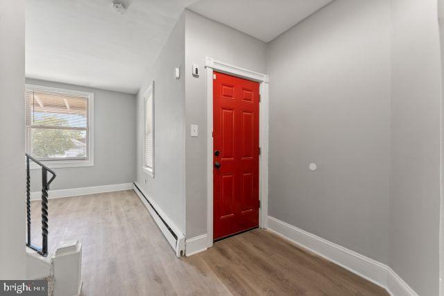 entryway with hardwood / wood-style floors and a baseboard radiator