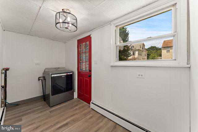 washroom with washer / dryer, baseboard heating, and hardwood / wood-style floors