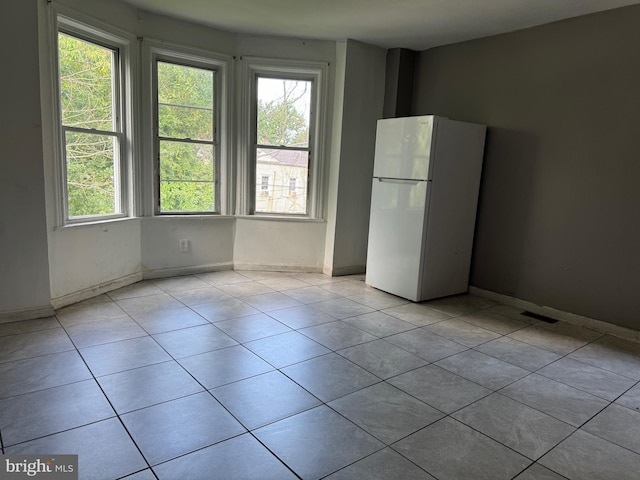 empty room with light tile patterned flooring and baseboards