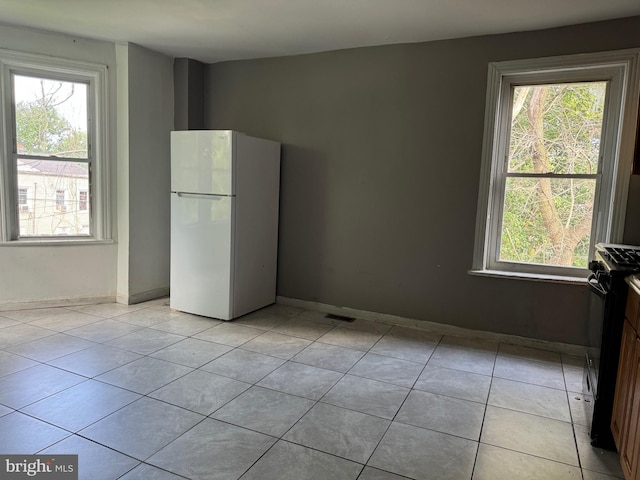 interior space with light tile patterned floors and baseboards