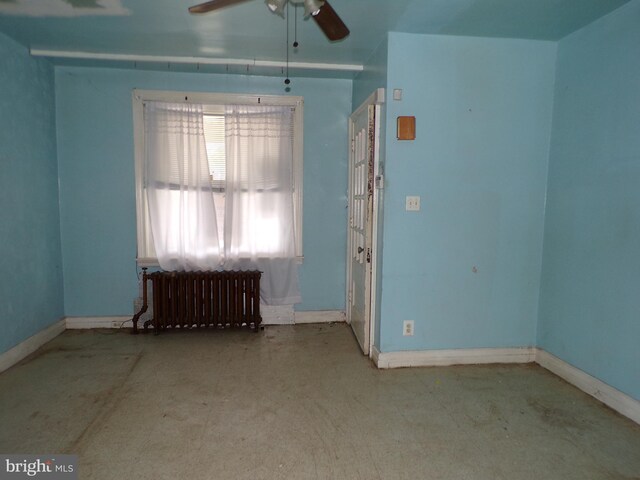 spare room featuring ceiling fan and radiator heating unit