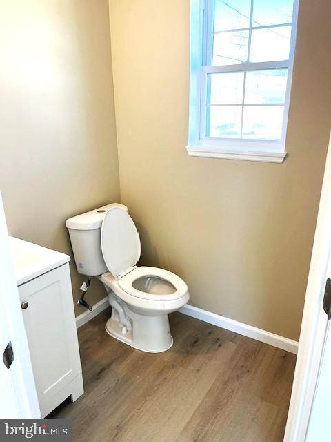 bathroom featuring vanity, toilet, and hardwood / wood-style floors