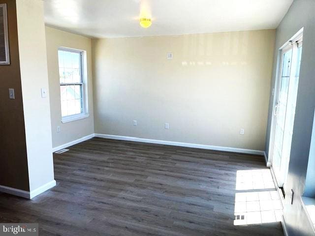 unfurnished room with dark wood-type flooring