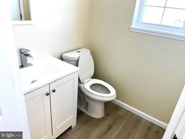 bathroom featuring vanity, wood-type flooring, and toilet