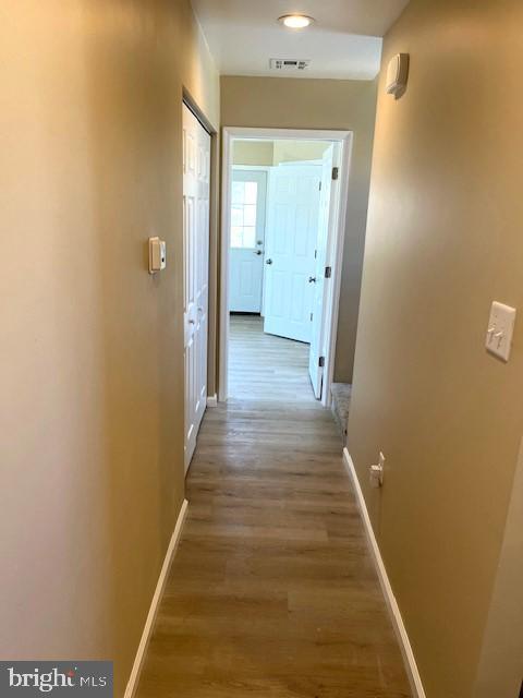 hallway with hardwood / wood-style floors