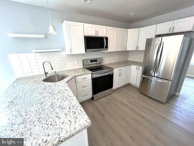 kitchen with stainless steel appliances, sink, and white cabinets