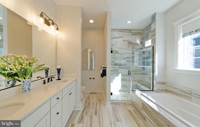 full bathroom featuring vanity, toilet, and independent shower and bath