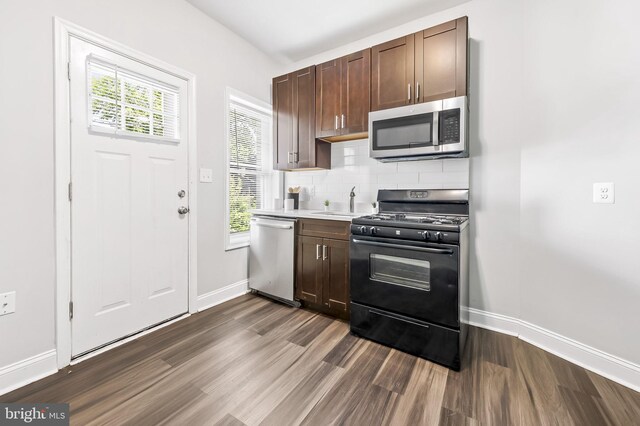 kitchen with appliances with stainless steel finishes, backsplash, dark brown cabinetry, and a healthy amount of sunlight