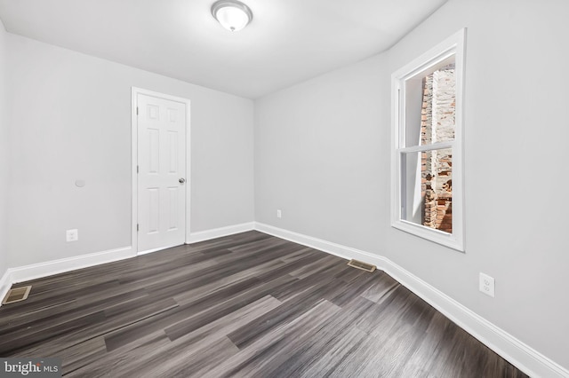 unfurnished room featuring dark hardwood / wood-style flooring