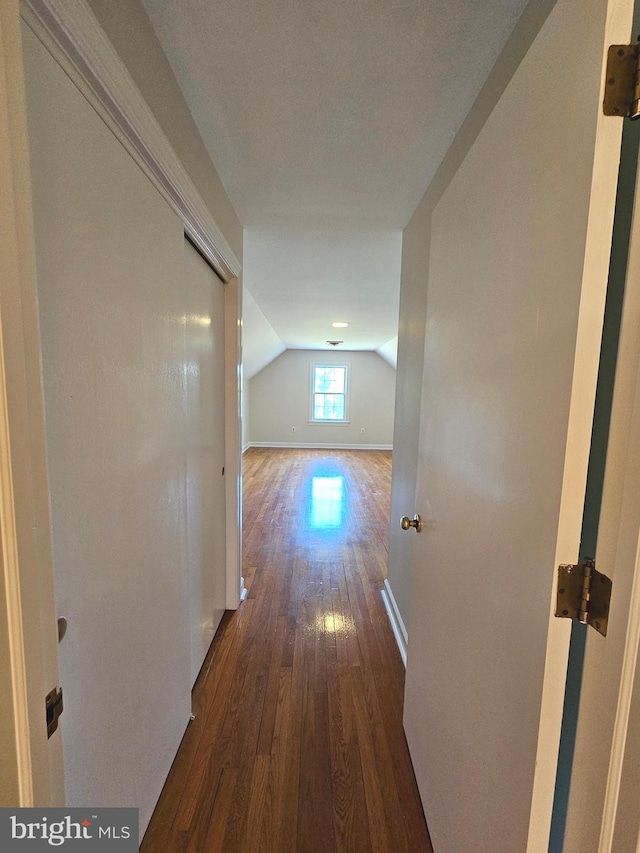 hallway featuring lofted ceiling and dark hardwood / wood-style flooring