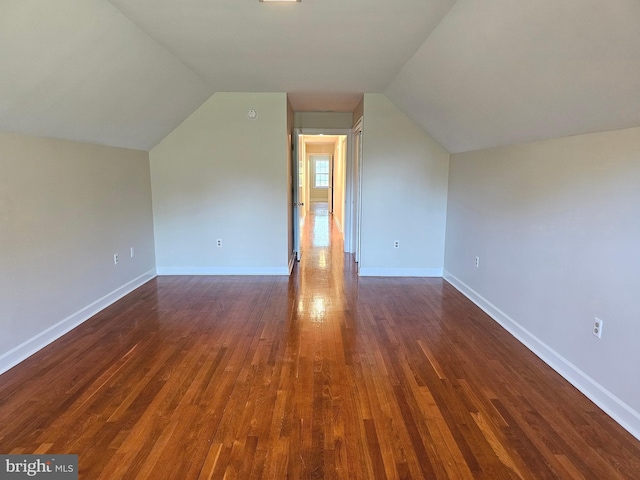 additional living space with dark wood-type flooring and vaulted ceiling