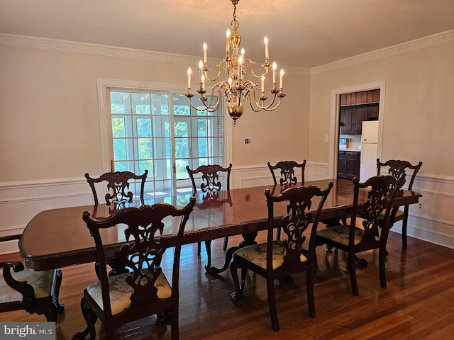 dining room with crown molding, dark hardwood / wood-style flooring, and a chandelier