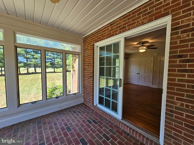 unfurnished sunroom with ceiling fan