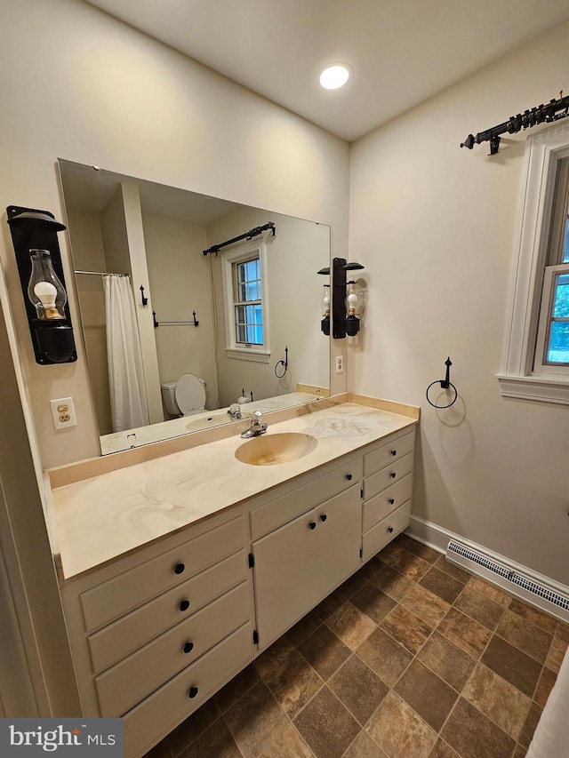 bathroom with vanity, toilet, and plenty of natural light