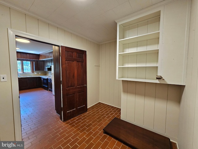 hall with ornamental molding and wood walls