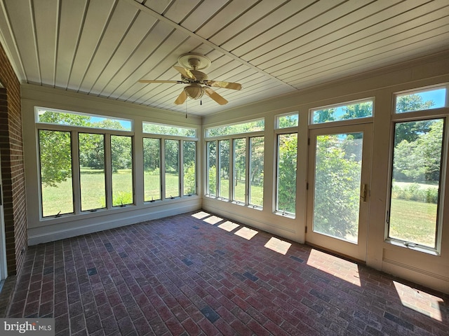 unfurnished sunroom featuring ceiling fan