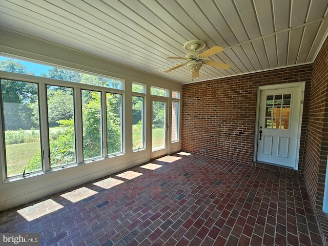 unfurnished sunroom featuring wood ceiling and ceiling fan