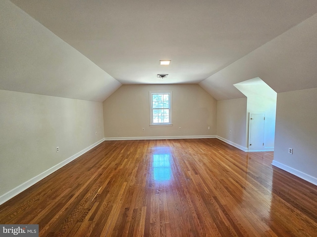 bonus room with hardwood / wood-style flooring and vaulted ceiling