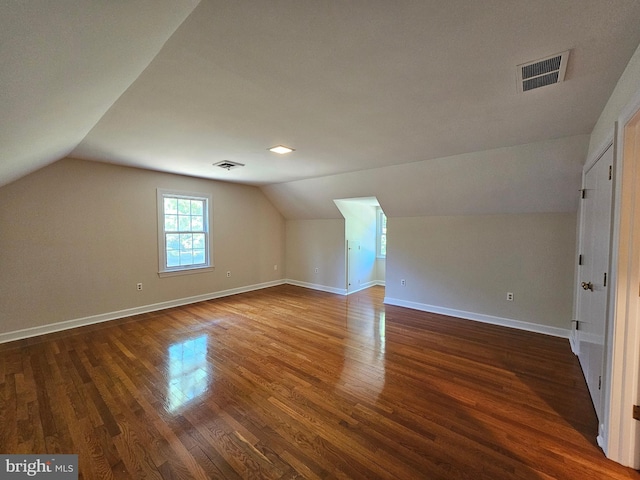 additional living space featuring lofted ceiling and dark hardwood / wood-style flooring