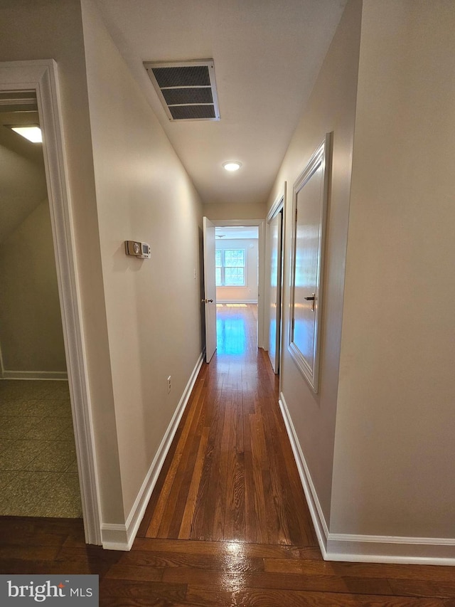 corridor with dark hardwood / wood-style flooring