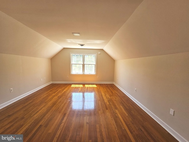 additional living space with lofted ceiling and dark hardwood / wood-style floors