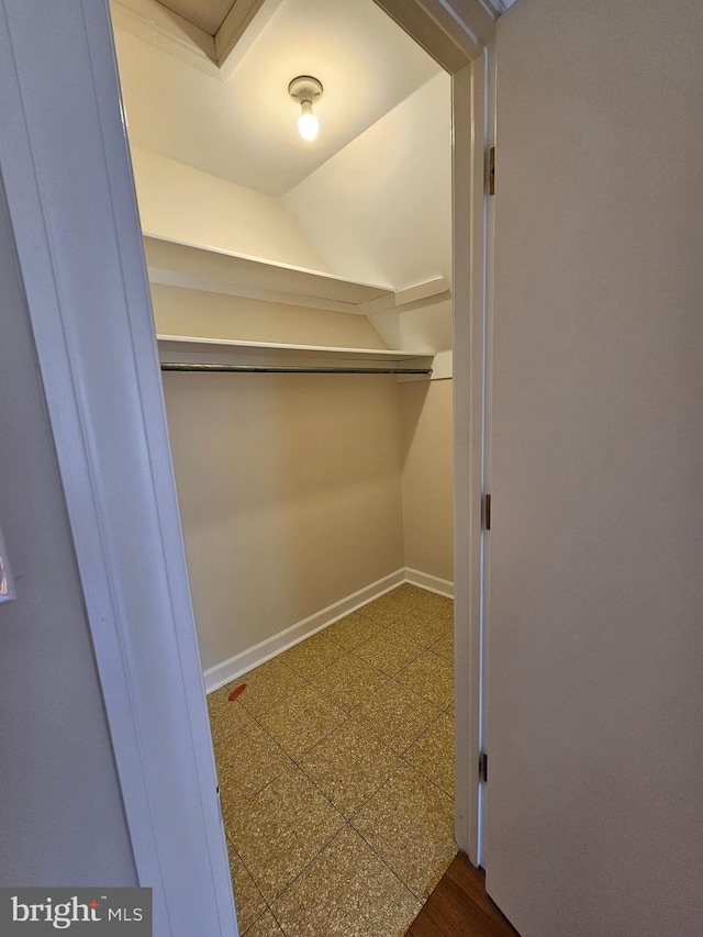 walk in closet featuring vaulted ceiling