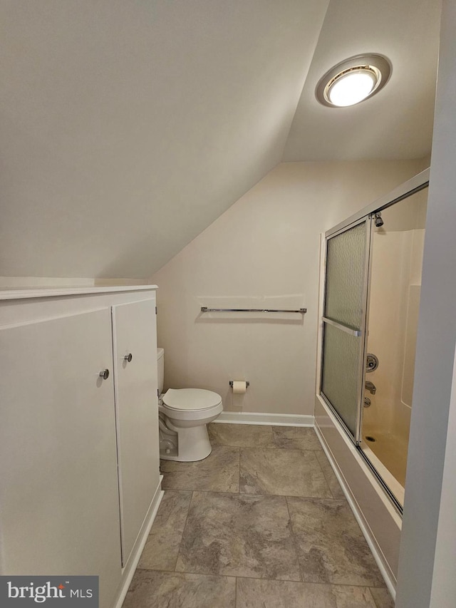 bathroom featuring lofted ceiling, bath / shower combo with glass door, and toilet